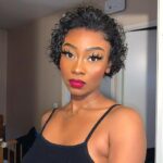 A woman with a Short Curly Pixie Cut 13x4 Lace Front Wig and makeup posing for the camera.